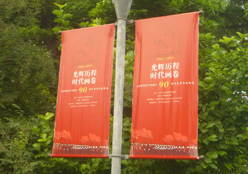 small banners hanging from a lamp post