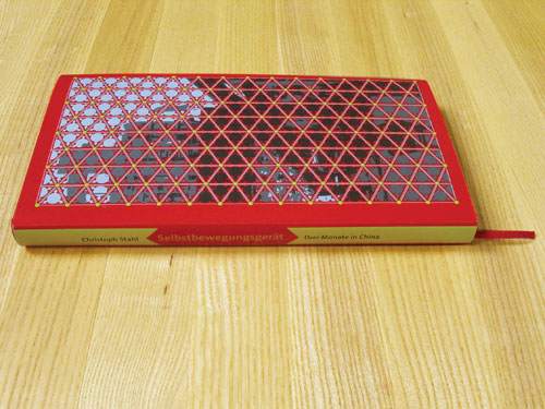 A red book with yellow back and a triangle-grid-structure
